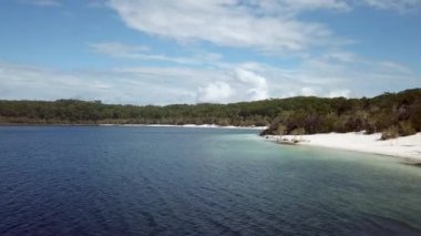 Allom Gölü üzerinde alçak açılı insansız hava aracının hızlı uçuşunun 4k görüntüsü. Fraser Adası, Queensland, Avustralya 'nın ünlü tatlı su göllerinden biri. Göl tatlı su kaplumbağalarıyla ünlüdür.
