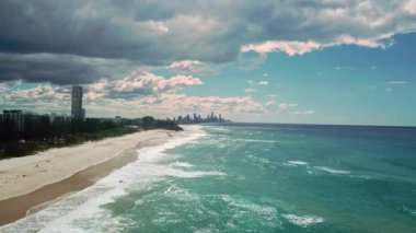 Bir grup sörfçü Gold Coast 'ta büyük bir dalganın üzerinde kürek çekiyor. Cesur ve korkusuz soğuk su sörfçüsü büyük güçlü dalgalarda yüzer, mükemmel sörf noktasına ulaşmak için kürek çeker.