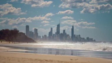 Gold Coast, Queensland, Avustralya. Sahilde yürüyen ve sörf tahtası taşıyan bir grup insan. Sörfçü cenneti.