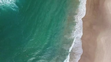Bir grup sörfçü Gold Coast 'ta büyük bir dalganın üzerinde kürek çekiyor. Cesur ve korkusuz soğuk su sörfçüsü büyük güçlü dalgalarda yüzer, mükemmel sörf noktasına ulaşmak için kürek çeker.