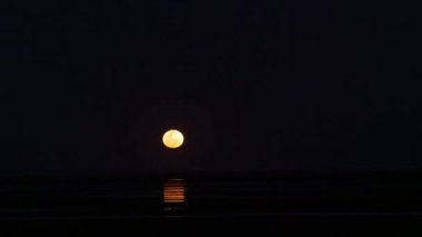 Dolunay gecesinin doğal arka plan görüntüleri. Gece vakti gökyüzünün manzarası var. Dolunay en karanlık gecede yavaşça gökyüzüne yükselir. gece ortamı