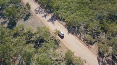 Beyaz bir minibüsün yörüngesinde dönen İHA, Avustralya 'nın batısındaki Karijini yakınlarındaki Avustralya çalılığından geçen Asutralı kırmızı toprak bir yolda ilerliyor..