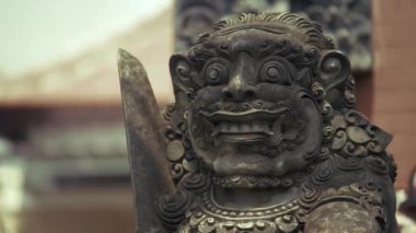 Endonezya 'daki bir Bali adasındaki pirinç yeşili tarlalardaki Barong heykelinin videosu. Köprüyü koruyor. Hareket eden kamera..