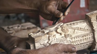 Keskin aletler ile oyma ahşap iş parçası üzerinde yapma woodcarver. Geleneksel Balinese heykelciği yapma işlemi. 4 k. Bali, Endonezya