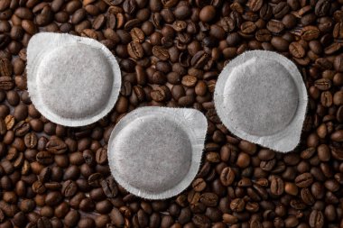 Kahve makinası için kahve çekirdeği arka planında kağıt kapsüller