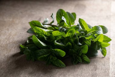 Masada taze toplanmış nane aromalı bitkiler var.