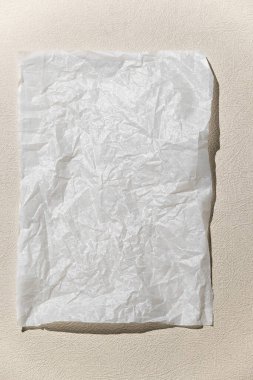 Nötr tek renkli arkaplan ve beyaz boş bir kağıt. Üst görünüm, nötr renklerde en az biçim, metin için boşluk.