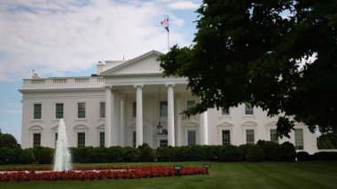 Baharda fıskiyeler, yeşil çimenler, ağaçlar ve bayraklar dalgalanan Beyaz Saray 'ın kuzey tarafına bakın..