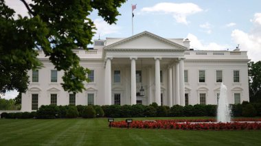 Beyaz Saray 'ın kuzey tarafının manzarası. İlkbaharda asılmış ağaç, çeşme, yeşil çimen ve bayraklar..