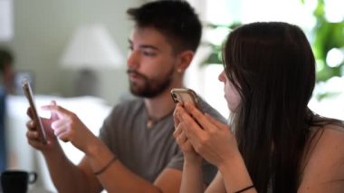 Genç bir çiftin konuşmaları ve bilgi paylaşmaları telefonlarıyla çalışmaları evlerindeki bir tezgahta konuşup mesajlaşmaları..