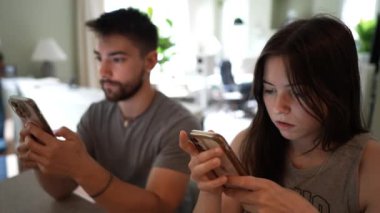 Akıllı telefon kullanan, mesajlaşan ve erkek arkadaşı odak mesafesi dışında olan genç bir kadının aşırı yakın çekimi..