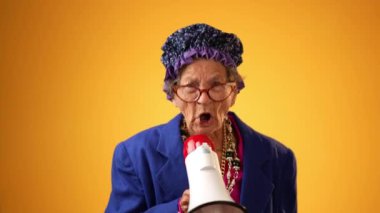 Mutlu gülümseyen çılgın büyükannenin komik portresi. 80 'li yaşlarda olgun bir kadın. Sarı arka planda izole edilmiş gibi davranıyor.