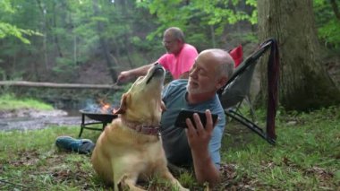 Ormanda kamp ateşinin önünde gitarlı ve köpekli iki eşcinsel aşk için kafalarını sandalyelere sürtüyor..