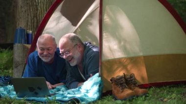 Çadırın önünde gururlu bayraklı iki eşcinsel akıllı telefonlu selfie çekiyor..
