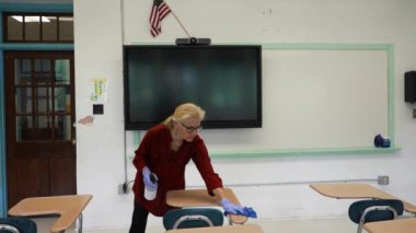 Sprey şişe, eldiven, bez, silme, temizlik ve okul sıralarını dezenfekte eden kadın öğretmenlerin el resimleri..