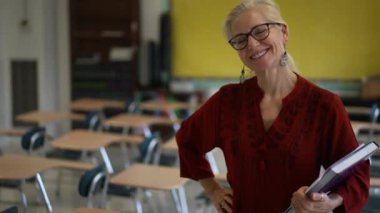 Sınıftaki gülümseyen kadın öğretmenin portresi yukarı bakar ve başparmağını kaldırır. Arka planda Amerikan bayrağı.