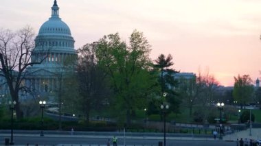 Kamyon görüntüsü solda, gece Washington DC 'de mavi mor gökyüzüne karşı sallanan ışık ve bayraklarla Birleşik Devletler Kongre Binası' nı gösteriyor..