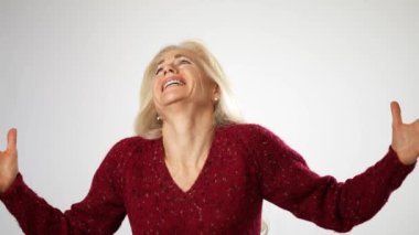 Kızgın, korkmuş, kafası karışmış olgun orta yaşlı kadın elini uzattı ve neden beyaz arka plan stüdyosunda soyutlandığımı sordu. İnsanlar yaşam tarzı duyguları konsepti.