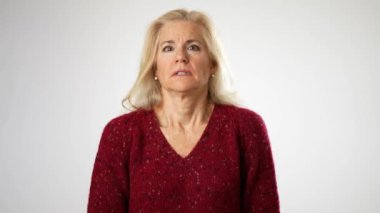 Öfkeli, öfkeli, olgun bir kadın el kaldırıyor. Öfke dolu, agresif, sinirli ve sinirli bir şekilde bağırıyor. Beyaz arka planda izole edilmiş kapalı stüdyo çekimi