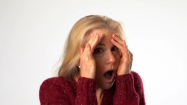 Yetişkin bir kadının portresi. Şok olmuş, şaşırmış, korkmuş, gözleri kapalı, sağlam beyaz arka planda soyutlanmış..