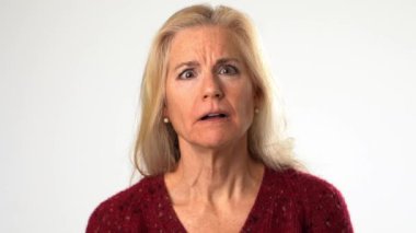 Büyük başarılar bekleyen olgun bir kadının yakınlaşması hayal kırıklığı, üzüntü, başarısızlık ve katı beyaz arka planda izole bir şekilde son bulur. Stüdyoda modelin yakın plan portresi.