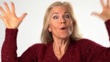 Heyecanlı, şaşırmış, gülümseyen olgun bir kadının yakın plan portresi. Beyaz arka plandaki izole edilmiş sarı saçlı, gülümseyen bir kadın.