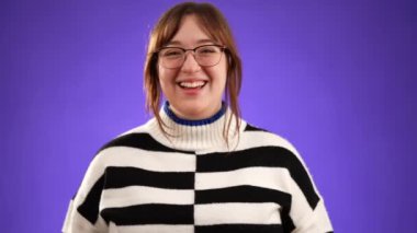 20 'li yaşlarda genç bir kadının portresi kameraya bakıyor alkışlıyor alkışlıyor olumlu duygu ve destek gösteriyor mor arka planda izole edilmiş iyi bir performansa.