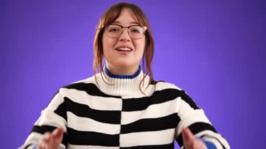 Mutlu gülümseyen 20 'li yaşların portresi kollarını ve ellerini kameraya uzatarak sarılmak için mor arka planda izole edilmiş bir şekilde uzanır.