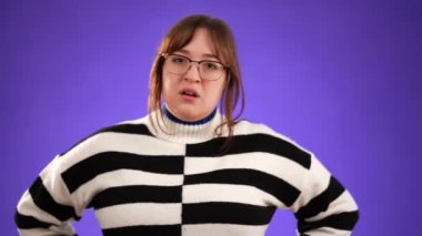 Kızgın ümitsizliğin portresi mutsuz 20 'li yaşlarda, mor arka planda izole edilmiş genç bir kadını üzdü..