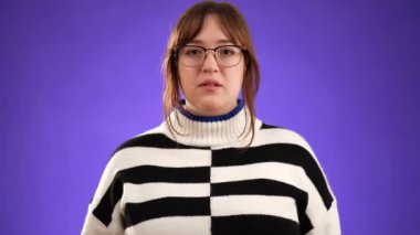 Şok olmuş korkmuş esmer kadın portresi mor arka plan stüdyosunda yalnız poz veriyor. İnsanların yaşam tarzı konsepti. Ağız kaplayan gözler ve saklanan eller.