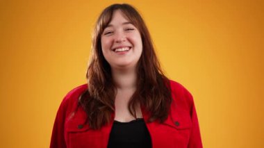 Kahverengi saçlı, gülen, kırmızı ceketli genç bir kadın. Başıyla onaylıyor. Evet, onaylıyor..