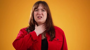 Kırmızı ceketli, 20 'li yaşlarda, boynu ağrıyan, sarı arka planda, fotokopi odası olan genç bir kadının portresi.