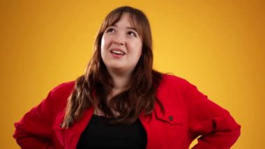 Esmer, uzun saçlı, 20 'li yaşlarda kırmızı ceket giyiyor. Etrafa bakıyor. Hayallerini düşün.