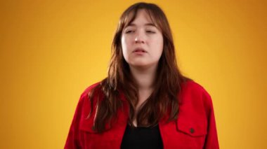 Beyaz kadın portresi, 20 'li yaşlarda sarı arka plan stüdyosunda kopyalanmış gizli şarkıları dinlemek için el ele tutuşuyor.