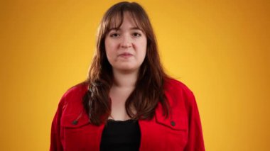 Sinirli ümitsizliğin portresi mutsuz genç bir kadını üzdü. 20 'li yaşlarda, sarı arka planda izole edilmiş..