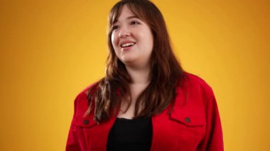 20 'li yaşlarda genç bir kadının portresi kameraya bakıyor. Harika bir performans sergileyen seyircinin alkışlarını kabul ediyor. İyi bir performans sergileyen insanlara teşekkür ediyoruz. Sarı arkaplanda izole edilmiş