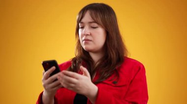 Sinirli, sosyal medya ya da haberler için stüdyodaki genç bayanla mesajlaşmanın portresi. Çevrimiçi dolandırıcılık, spam ve hayal kırıklığına uğramış sarı arka plandaki kadın..