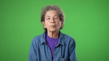 Mutlu gülümseyen yaşlı bir kadının portresi. Kırışık ciltli, yeşil perdede gri saçlı yaşlı bir kadın..
