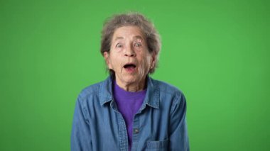 Gülümseyen yaşlı bir kadının portresi. Cildi kırış kırış ve saçları yeşil perde arkasında..