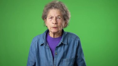 Öfkeli ümitsizlik, yaşlı yaşlı bir kadının hava portresiyle kaldırılan yeşil perde arkasında izole edilmiş kırışık derili ve gri saçlı elleri ile üzgün..