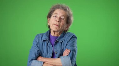 Mutlu gülümseyen yaşlı bir kadının portresi. Başıyla evet, kırışık bir cilt ve yeşil perde arkasında gri saçlar..