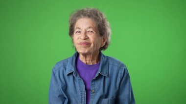 Yaşlı yaşlı bir kadının portresi, buruşuk derili, gri saçlı, boğazı ağrıyan, hasta, sağlıksız, yeşil ekranda izole edilmiş..