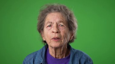Yaşlı bunalımlı yaşlı kadın 80 'li yaşlarda. Migren ağrısı var. Yeşil ekran arka plan stüdyosunda yalnız poz veriyor. İnsanların yaşam tarzı kavramına yakın olmak. Yüzünü dön.