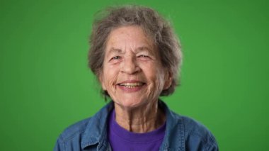 Mutlu yaşlı yaşlı kadın portresi. 80 'li yaşlarda. Stüdyoda fotokopi odası olan yeşil ekranda izole edilmiş.