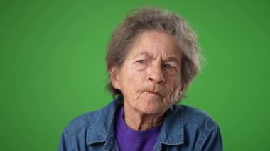 Düşünceli, yaşlı, dişsiz, yeşil perde arkasında fikri olan bir kadın..