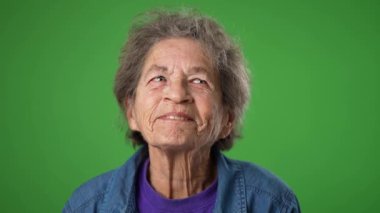 Düşünceli, yaşlı, dişsiz, yeşil ekran arka planda fikri olan bir kadın..