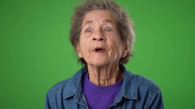 Yakın çekim komik portre gülümseyen mutlu yaşlı yaşlı kadın buruşuk tenli, gri saçlı, gülümseyen ve bana işaret eden yeşil ekranlı arka plan.