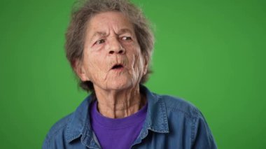 Yakın çekim, yaşlı mutlu yaşlı bir kadının komik portresi buruşuk derili, gri saçlı, gülümseyen ve arkadaşını arayan yeşil ekranda poz veren biriyle tanış..