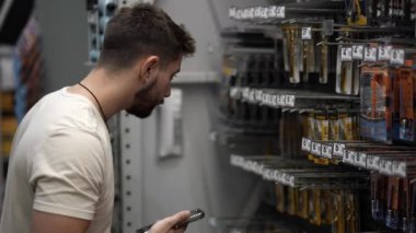 Charlottesville, VA, ABD - 07 23 2024: Hırdavatçı deposunda matkap ucu arayan adama yakın çekim.