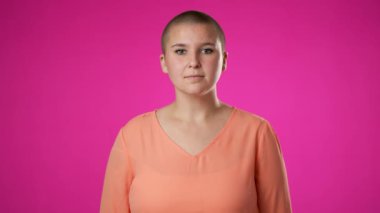 Gülümseyen genç kadın 20 'li yaşlarda pembe arka plan stüdyosunda yalnız poz veriyor. İnsanlar samimi duygular, yaşam tarzı konsepti. Çekici bir gülümsemeyle kameraya bakıyorum.